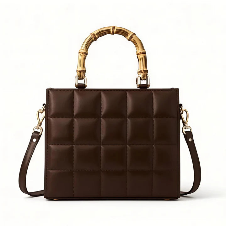 Brown quilted handbag with gold bamboo handle on a white background