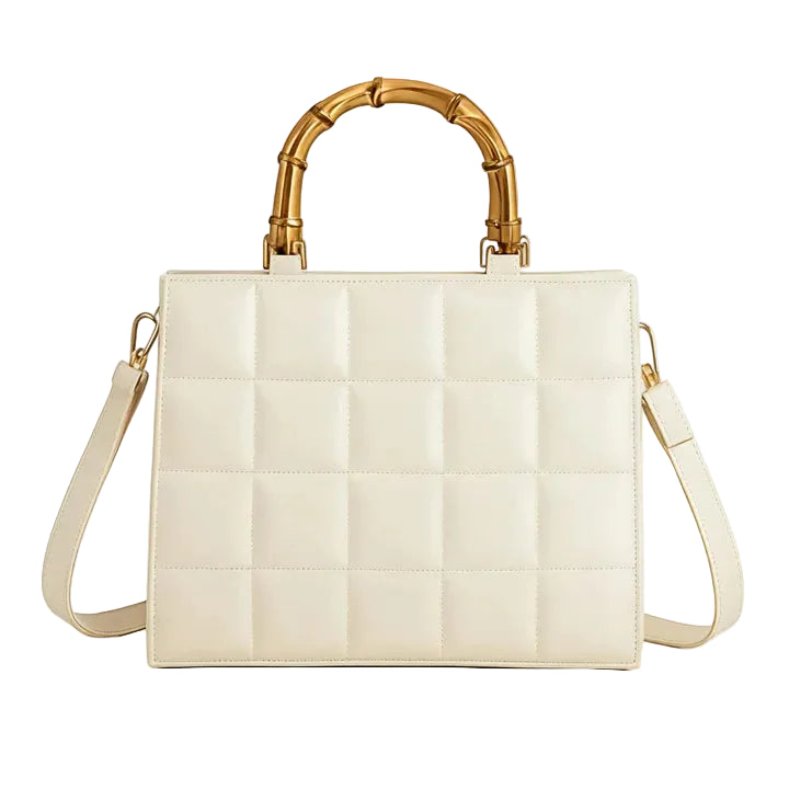 Beige handbag with gold bamboo handle on a white background