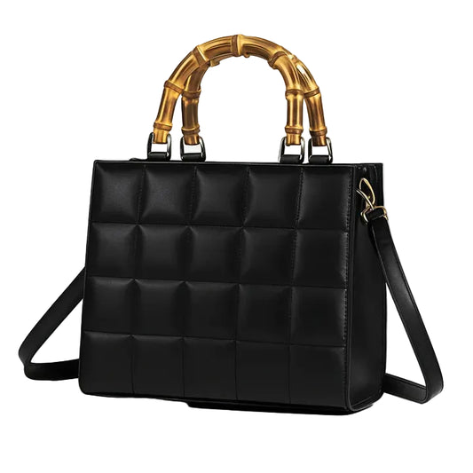 Black quilted handbag with gold bamboo handle on a white background