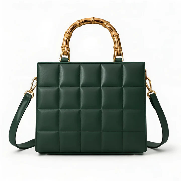 Green quilted handbag with gold bamboo handle on a white background
